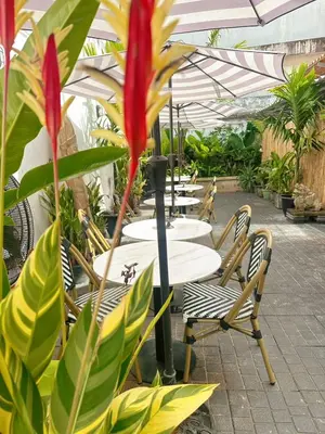 a row of tables and chairs under an umbrella at Beanstay hostel in Phuket Town