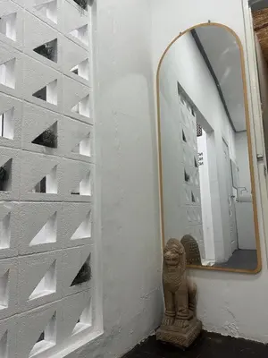 a mirror on the side of a wall with a lion statue at Beanstay hostel in Phuket Town