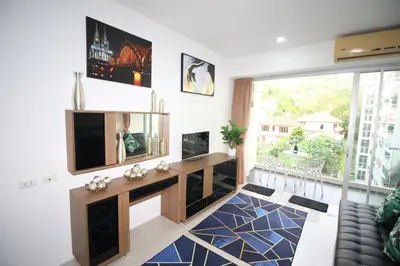 a living room with a television and a large window at Chic Condominium A 518 in Karon Beach