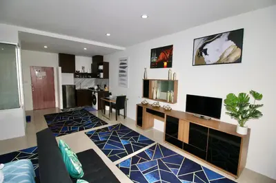 a living room with a couch and a tv in it at Chic Condominium A 518 in Karon Beach