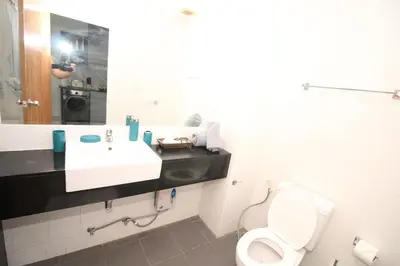 a bathroom with a toilet and a sink and a mirror at Chic Condominium A 518 in Karon Beach