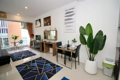 a living room with a table and chairs and a plant at Chic condominium A4 floor in Karon Beach