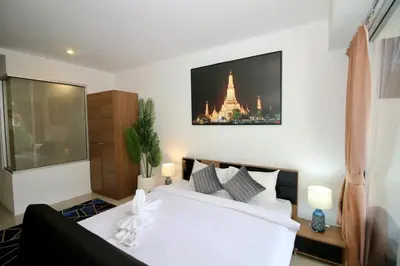a bedroom with a white bed with a picture on the wall at Chic condominium A4 floor in Karon Beach