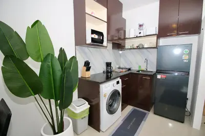 a kitchen with a washing machine and a plant at Chic condominium A4 floor in Karon Beach