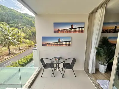 a balcony with a table and chairs and a bridge at Veloche 2 Floor in Karon Beach