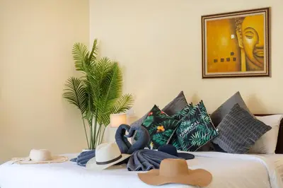 a bed with hats and towels on top of it at Rawai Beach Villa in Rawai Beach