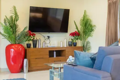 a living room with a tv on a wooden entertainment center at Rawai Beach Villa in Rawai Beach