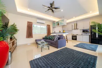 a living room with a couch and a ceiling fan at Rawai Beach Villa in Rawai Beach