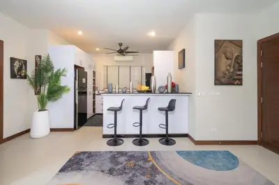 a kitchen with a counter and stools in a room at Naiharn Beach 4 Bedroom Villa in Nai Harn Beach