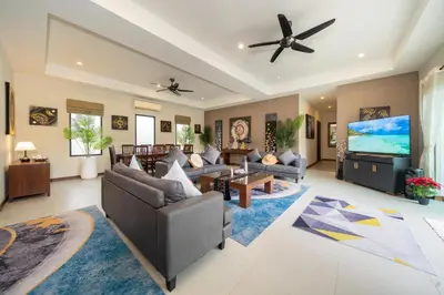 a living room with couches and a flat screen tv at Naiharn Beach 4 Bedroom Villa in Nai Harn Beach