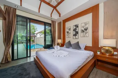 a bedroom with a large bed and a pool at Rawayana 3 Bedroom Villa in Rawai Beach