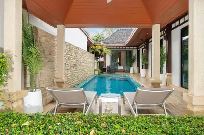 a swimming pool with chairs and a house at Rawayana 3 Bedroom Villa in Rawai Beach
