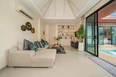 a living room with a couch and a swimming pool at Rawai Park Big Garden Villa 3D10 in Rawai Beach