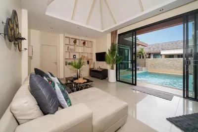a living room with a white couch and a pool at Rawai Park Big Garden Villa 3D10 in Rawai Beach
