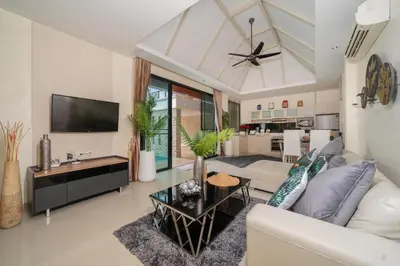a living room with a white couch and a tv at Rawai Park Big Garden Villa 3D10 in Rawai Beach