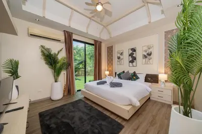 a bedroom with a bed and plants in it at Rawai Park Big Garden Villa 3D10 in Rawai Beach