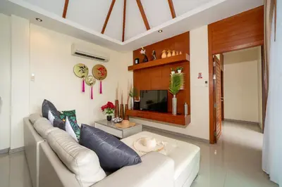 a living room with a white couch and a tv at Rawayana Beach Villa 3D14 in Phuket Town