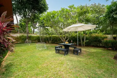 a picnic table with an umbrella in a yard at Rawayana Beach Villa 3D14 in Phuket Town