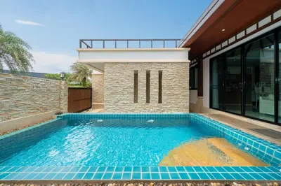 a swimming pool in front of a house at Rawayana Beach Villa 3D14 in Phuket Town