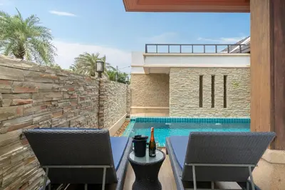 a patio with two chairs and a swimming pool at Rawayana Beach Villa 3D14 in Phuket Town