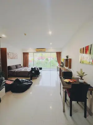a large living room with a bed and a table at Chic 10 minutes to reach the karon beach, with free swimming pool and gym, WIFI in Karon Beach