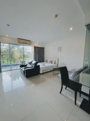 a living room with a couch and a chair at Chic 10 minutes to reach the karon beach, with free swimming pool and gym, WIFI in Karon Beach