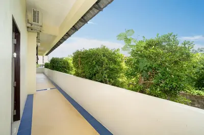 an empty balcony of a building with trees at JR Siam Inn Resort in Kata Beach