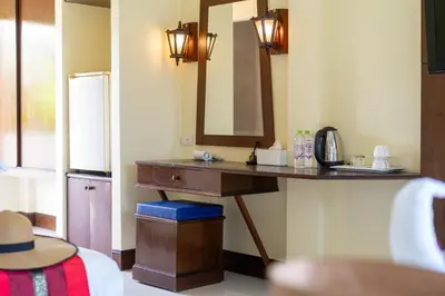 a bathroom with a vanity with a mirror and a sink at JR Siam Inn Resort in Kata Beach