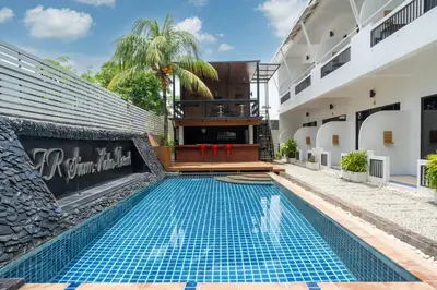 a swimming pool in front of a building at JR Siam Inn Resort in Kata Beach