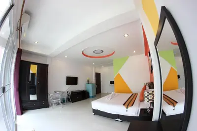 a hotel room with two beds and a mirror at Tulip Inn in Patong Beach