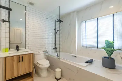 a bathroom with a toilet and a tub and a sink at Bee Villa Wellness Resort Phuket in Laguna Phuket