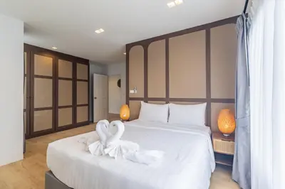 two swans sitting on a bed in a hotel room at Bee Villa Wellness Resort Phuket in Laguna Phuket