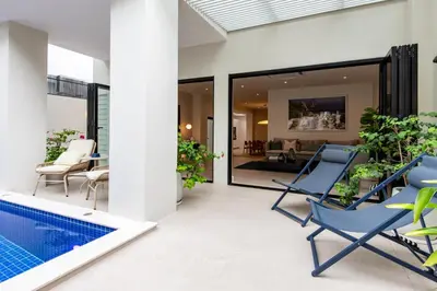 a patio with a blue chair and a swimming pool at Palazzo 126 Luxury 5BR Pool Villa in Patong in Patong Beach