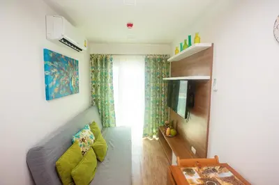 a living room with a couch and a table at Calypso Condo Naiharn in Phuket Town