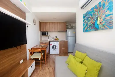 a living room with a kitchen and a dining room at Calypso Condo Naiharn in Phuket Town