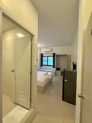 a bedroom with a bed and a refrigerator in a room at Kata Platinum in Kata Beach