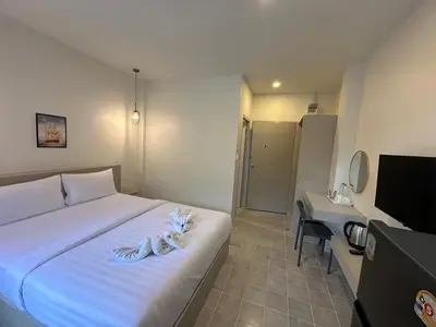 a bedroom with a bed and a desk and a television at Kata Platinum in Kata Beach