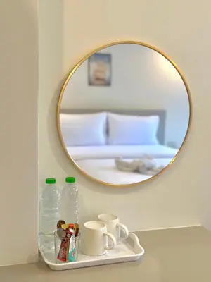 a mirror on a shelf with bottles and mugs at Kata Platinum in Kata Beach