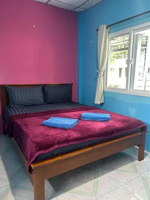 a bedroom with a bed with two blue pillows on it at Gypsy Village Resort in Phi Phi Don