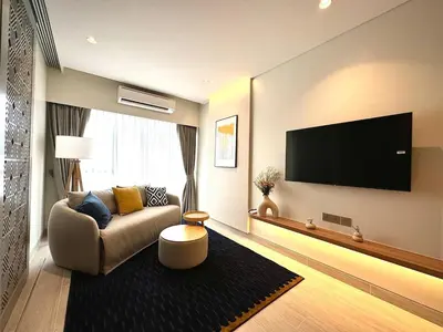 a living room with a couch and a flat screen tv at New apartments in a premium Laguna complex by the lake in Bang Tao Beach