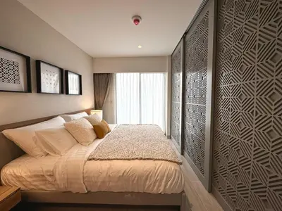 a bedroom with a bed and a wall with a window at New apartments in a premium Laguna complex by the lake in Bang Tao Beach
