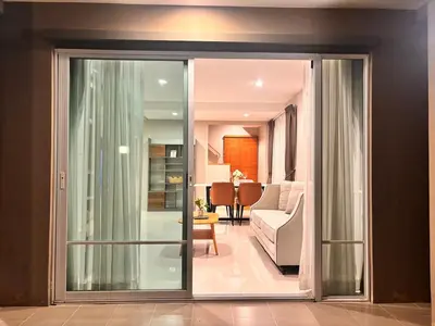 a living room with a sliding glass door to a living room at Modern 3 BR Villa Pool&Gym only 15min to Bang Tao Beach in Ban Phru Champa