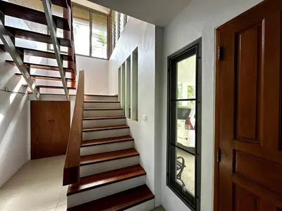 a staircase in a house with a wooden door at Casa Sakoo pool Villa Naithon in Nai Thon Beach
