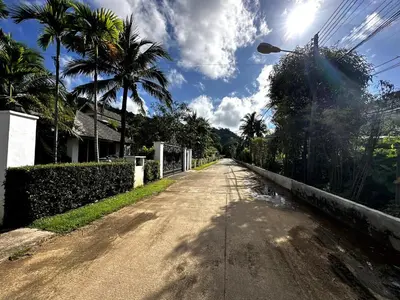 an empty road with palm trees on the side at Casa Sakoo pool Villa Naithon in Nai Thon Beach