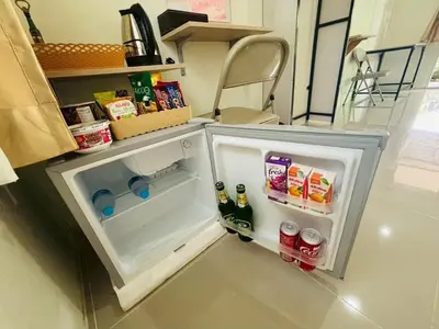 a small refrigerator with its door open in a kitchen at 3P Phuket Airport Hotel in Phuket