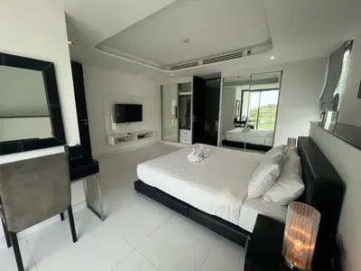 a large bedroom with a bed and a mirror at Twin Sand Phuket by PPR in Patong Beach