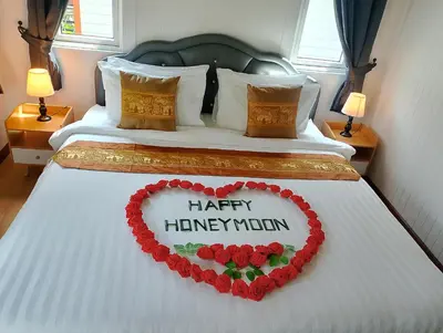 a bed with a heart made out of roses at The white resort & restaurant koh yao yai in Ban Khlong Hia