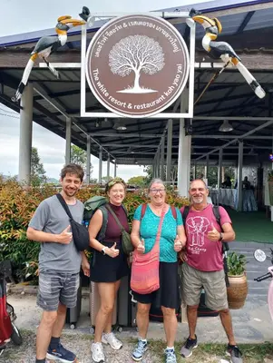 a group of people standing in front of a sign at The white resort & restaurant koh yao yai in Ban Khlong Hia