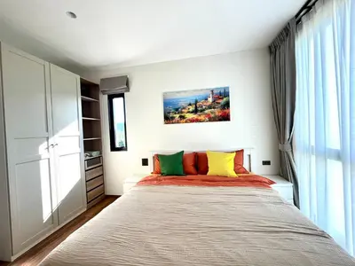 a bedroom with a large bed with colorful pillows at Halo 1 , 2 bedroom, 400m to the see in Nai Yang Beach