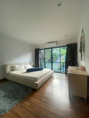 a bedroom with a large bed and a large window at Town House in Ban Ket Ho